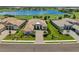 Stunning aerial view of a home with lush landscaping and a beautiful lake backdrop in a golf community at 3936 Santa Caterina Blvd, Bradenton, FL 34211
