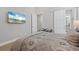 Spacious bedroom featuring barn door access to the bathroom, light floors, and wall-mounted television at 3936 Santa Caterina Blvd, Bradenton, FL 34211