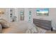 Bright bedroom featuring en suite bath, plush rug, and elegant gray dresser with wall-mounted television at 3936 Santa Caterina Blvd, Bradenton, FL 34211