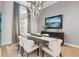 Elegant dining room featuring modern chandelier, long table, and large windows with natural light at 3936 Santa Caterina Blvd, Bradenton, FL 34211