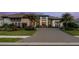 Beautiful home with a stone paver driveway, tropical landscaping, and a charming exterior lighting at 3936 Santa Caterina Blvd, Bradenton, FL 34211