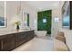 Spa-like main bathroom featuring dual sinks, a soaking tub, and a vertical green wall at 3936 Santa Caterina Blvd, Bradenton, FL 34211