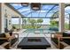 Lavish screened outdoor living area featuring a gorgeous pool, lake view, and comfortable seating arrangements at 3936 Santa Caterina Blvd, Bradenton, FL 34211