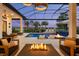 Inviting outdoor living space with a fire pit, lounge chairs, pool, and scenic views at 3936 Santa Caterina Blvd, Bradenton, FL 34211