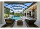 Expansive outdoor living area with a pool, spa, submerged lounge chairs, an outdoor kitchen, and seating areas at 3936 Santa Caterina Blvd, Bradenton, FL 34211
