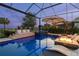 Relaxing pool area with lounge chairs, a fire pit, and a spa against a backdrop of lush greenery and evening skies at 3936 Santa Caterina Blvd, Bradenton, FL 34211
