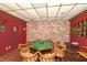 Basement game room featuring an octagonal poker table with red walls and patterned flooring at 4380 Exeter Dr # 204, Longboat Key, FL 34228
