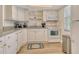 Charming kitchen featuring white cabinets, updated appliances, and granite countertops at 4380 Exeter Dr # 204, Longboat Key, FL 34228