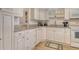 Well-equipped kitchen with white cabinetry, granite counters, and modern appliances at 4380 Exeter Dr # 204, Longboat Key, FL 34228