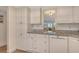 Bright kitchen with white cabinets and updated appliances, featuring a granite countertop at 4380 Exeter Dr # 204, Longboat Key, FL 34228