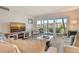 Comfortable living room offers lanai access with views; furnished with sofa, chair, and modern TV at 4380 Exeter Dr # 204, Longboat Key, FL 34228