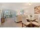 Bright living room with dining area, patio doors to screened lanai, light walls and wood floors at 4380 Exeter Dr # 204, Longboat Key, FL 34228