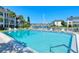 Community pool with clear blue water, lounge chairs, and canal views at 4380 Exeter Dr # 204, Longboat Key, FL 34228