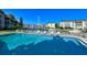 Sparkling community pool surrounded by lounge chairs, and a view of the canal with boats at 4380 Exeter Dr # 204, Longboat Key, FL 34228