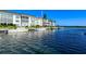 Waterfront view of condos and boats along the canal under a bright blue sky at 4380 Exeter Dr # 204, Longboat Key, FL 34228