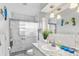Modern bathroom with marble tile, glass shower, granite vanity, and decorative seahorse wall decor at 453 Sandlewood Dr, Venice, FL 34293