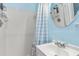 Cozy bathroom features blue walls, a shower with blue and white curtains and a white sink at 453 Sandlewood Dr, Venice, FL 34293