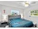 Cozy bedroom with large windows providing natural light and featuring a ceiling fan and tasteful decor at 453 Sandlewood Dr, Venice, FL 34293