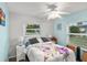 Bright bedroom with large windows and a ceiling fan, decorated with stylish accents and colorful floral bedding at 453 Sandlewood Dr, Venice, FL 34293