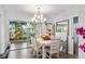 Cozy dining room featuring a chandelier, seating for six, and sliding door access to a sunroom at 453 Sandlewood Dr, Venice, FL 34293