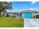 Charming single-story home with a well-manicured lawn, a bright blue garage door, and inviting front patio at 453 Sandlewood Dr, Venice, FL 34293