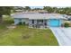 Charming single-story home with a well-manicured lawn, a bright blue garage door, and inviting front patio at 453 Sandlewood Dr, Venice, FL 34293