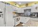 Bright kitchen with white cabinetry, granite countertops, tile backsplash, and stainless steel appliances at 453 Sandlewood Dr, Venice, FL 34293