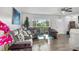 Comfortable living room featuring a gray sectional couch, plush pillows, and large picture window at 453 Sandlewood Dr, Venice, FL 34293