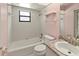 Clean and bright bathroom with pink accents featuring a tub, toilet, and sink with granite countertop at 4805 Cypress Lake Ct, Sarasota, FL 34243