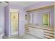 Clean bathroom featuring a shower with a glass door, white cabinets, a sink, and a large mirror at 4805 Cypress Lake Ct, Sarasota, FL 34243