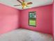 Bright bedroom with pink walls, ceiling fan, and a window providing natural light and a view at 4805 Cypress Lake Ct, Sarasota, FL 34243