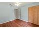 Well-lit bedroom featuring laminate wood flooring, ceiling fan, and closet with wooden doors at 4805 Cypress Lake Ct, Sarasota, FL 34243