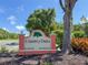 A welcoming 'Country Oaks' neighborhood sign, set amidst lush greenery, conveys a sense of community at 4805 Cypress Lake Ct, Sarasota, FL 34243