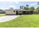 Exterior home view with a large front yard, mature landscaping, and a long driveway leading to the property at 4805 Cypress Lake Ct, Sarasota, FL 34243