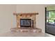 Cozy stone fireplace with a wooden mantel, creating a warm focal point in the light and airy living space at 4805 Cypress Lake Ct, Sarasota, FL 34243