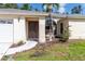 A welcoming home entrance features a well-maintained lawn, mature plantings and a decorative water feature at 4805 Cypress Lake Ct, Sarasota, FL 34243