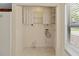 Bright laundry room with shelving, tile flooring, and a window bringing in natural light at 4805 Cypress Lake Ct, Sarasota, FL 34243