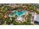 Aerial view of a resort-style pool surrounded by lush landscaping and palm trees at 4916 Tivoli Run, Bradenton, FL 34211