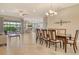 Spacious dining room area showcasing an open floor plan, modern chandelier, and sliding glass doors at 4916 Tivoli Run, Bradenton, FL 34211