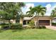 Beautiful single Gathering home featuring a tile roof, brick driveway, and lush landscaping with palm trees at 4916 Tivoli Run, Bradenton, FL 34211