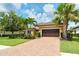 Beautiful single Gathering home featuring a tile roof, brick driveway, and lush landscaping with palm trees at 4916 Tivoli Run, Bradenton, FL 34211