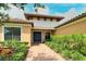Close up of the front door and landscaping of a tan house with beautiful terra-cotta colored roof at 4916 Tivoli Run, Bradenton, FL 34211