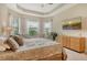 Main bedroom features tray ceilings, multiple windows, light-colored walls and floors, and neutral furniture at 4916 Tivoli Run, Bradenton, FL 34211