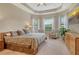Main bedroom features tray ceilings, multiple windows, light-colored walls and floors, and neutral furniture at 4916 Tivoli Run, Bradenton, FL 34211