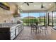 This screened patio features a ceiling fan, outdoor kitchen and dining area overlooking the landscaped backyard at 4916 Tivoli Run, Bradenton, FL 34211