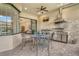 This screened patio features a ceiling fan, outdoor kitchen and dining area with a view of the backyard at 4916 Tivoli Run, Bradenton, FL 34211
