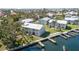 Aerial view showcasing waterfront condo buildings with docks, lush landscaping, and waterways at 522 Pine Ave # 8B, Anna Maria, FL 34216