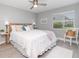 Bright bedroom featuring a comfortable bed, ceiling fan, and sunlit window with neighborhood view at 522 Pine Ave # 8B, Anna Maria, FL 34216