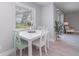 Bright dining area featuring a white table with seafoam green chairs and a large window for natural light at 522 Pine Ave # 8B, Anna Maria, FL 34216