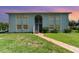 Charming building with a well-manicured lawn and a brick pathway leading to the entrance at 522 Pine Ave # 8B, Anna Maria, FL 34216
